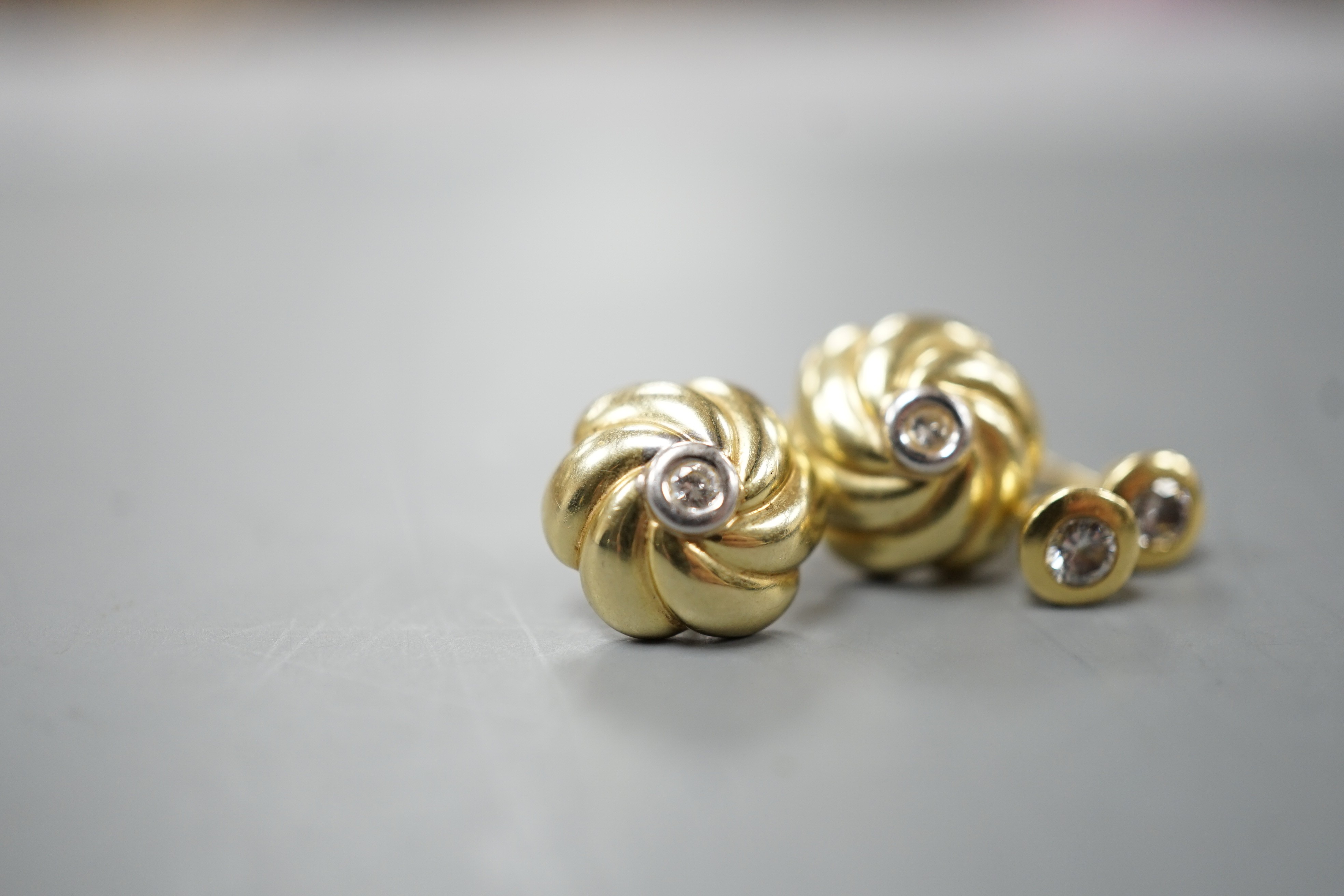 Two pairs of yellow metal and small solitaire diamond set ear studs, gross weight 5.2 grams.